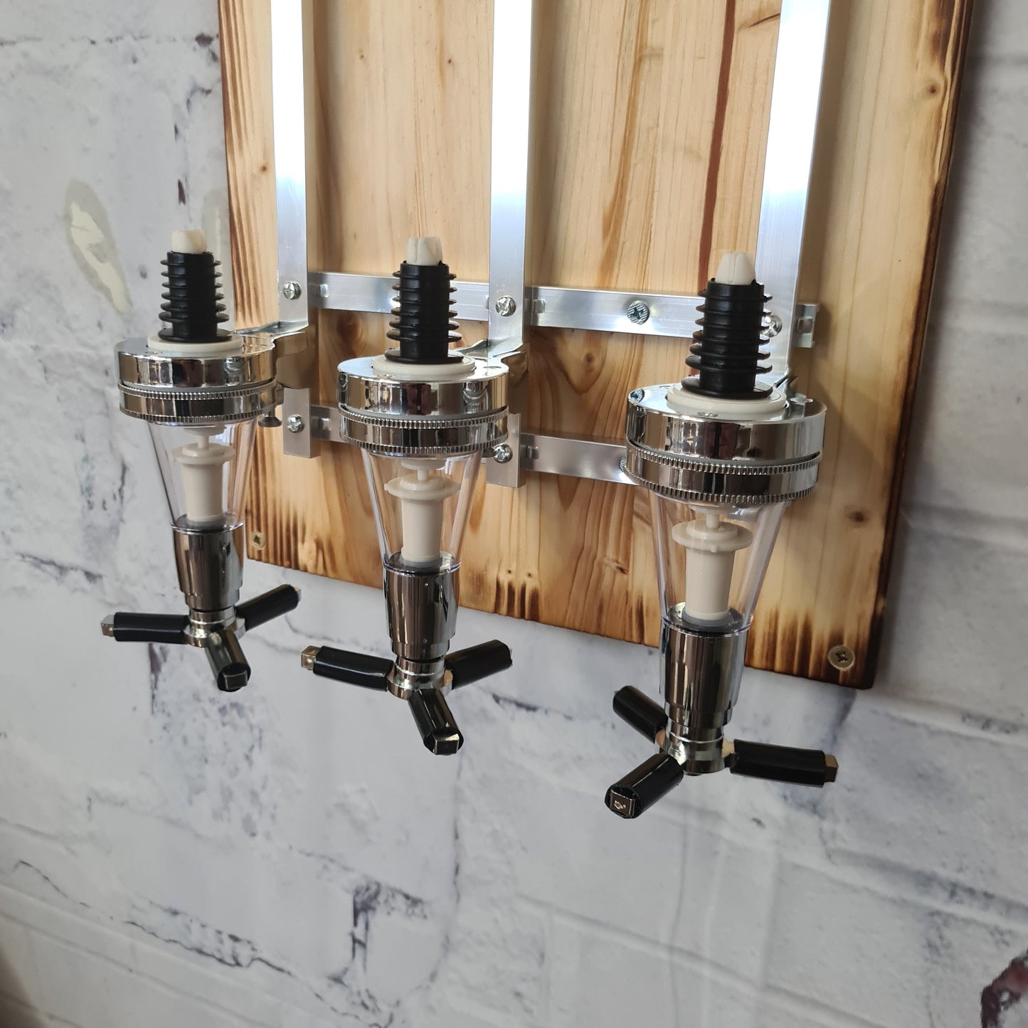 Wandhalterung aus Holz mit drei verchromten Spirituosenspendern, modern rustikal