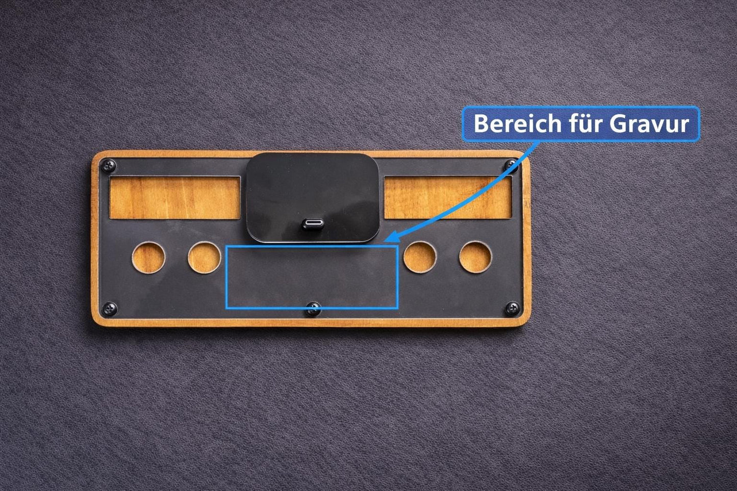 Holz-Schlüsselbrett mit USB-C Ladefläche und markiertem Bereich für Gravur auf schwarzem Hintergrund