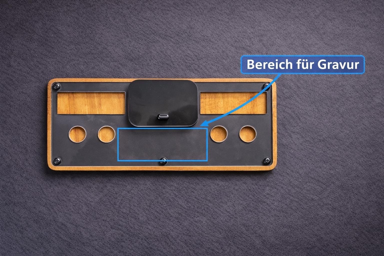 Holz-Schlüsselbrett mit USB-C Ladefläche und markiertem Bereich für Gravur auf schwarzem Hintergrund