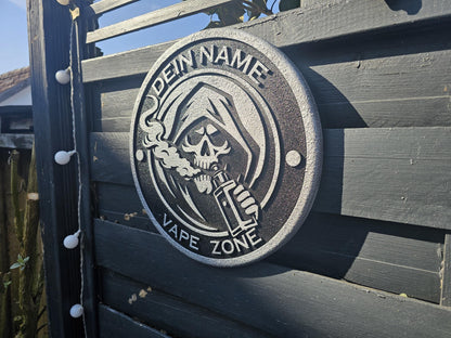 Metallschild mit Sensenmann, der dampft, Gravur 'Dein Name Vape Zone', an Holzzaun