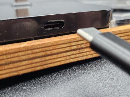 Nahaufnahme eines USB-C-Anschlusses und Kabels, moderne Technik auf Holztisch