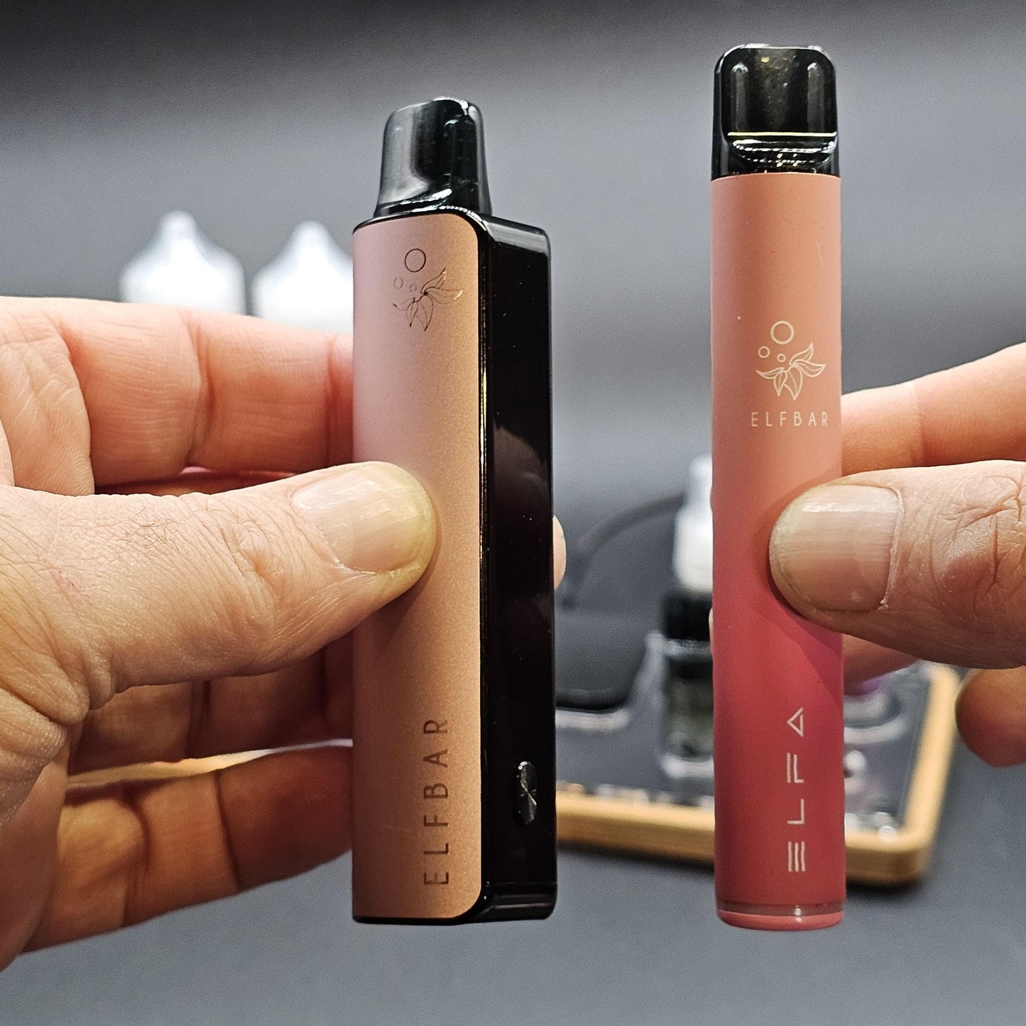Zwei ELF BAR E-Zigaretten werden in Händen gehalten, moderne E-Shisha Geräte, Nahaufnahme.