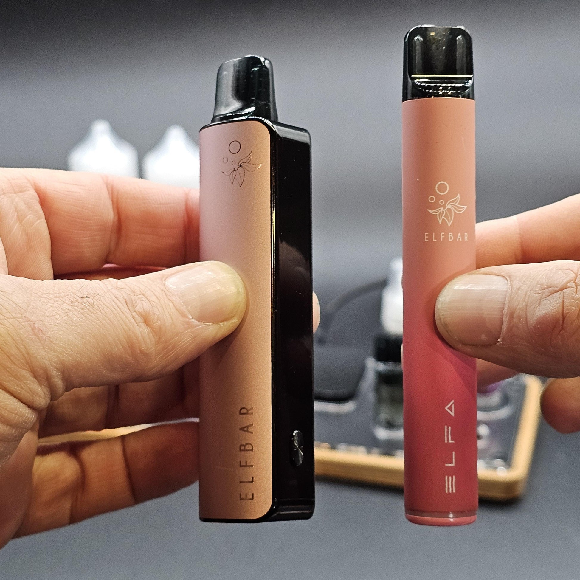 Zwei ELF BAR E-Zigaretten werden in Händen gehalten, moderne E-Shisha Geräte, Nahaufnahme.